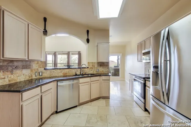a large kitchen with cabinets and stainless steel appliances