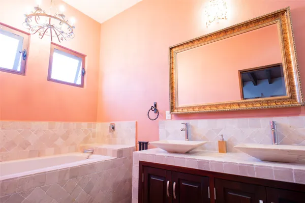a bathroom with a tub sink and mirror
