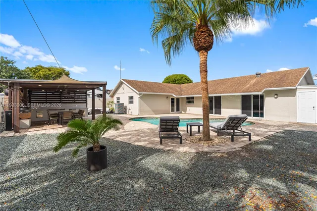 a view of a house with backyard and sitting area