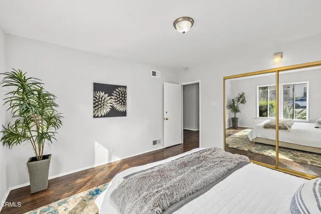 a bedroom with bed and a potted plant