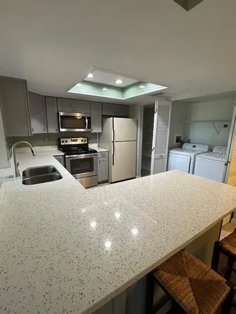 a kitchen with stainless steel appliances a refrigerator sink and stove