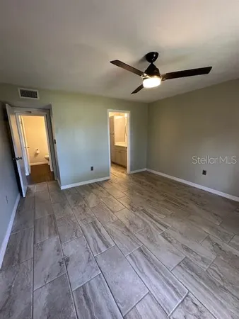 a view of a livingroom with a ceiling fan and wooden floor