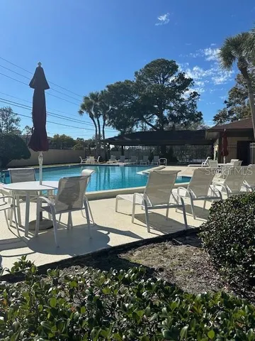 a view of a chairs and table in patio with a lake view