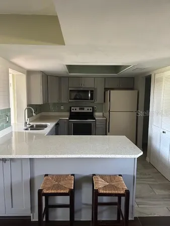 a kitchen with a table chairs refrigerator and microwave