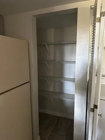 a view of walk in closet with empty racks