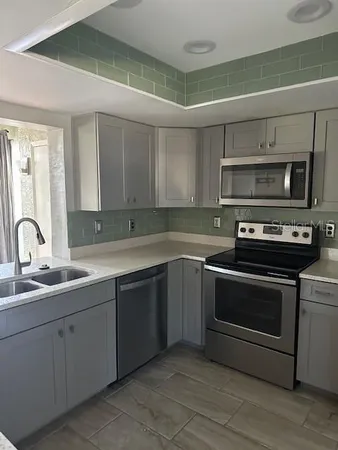 a kitchen with sink a microwave and cabinets