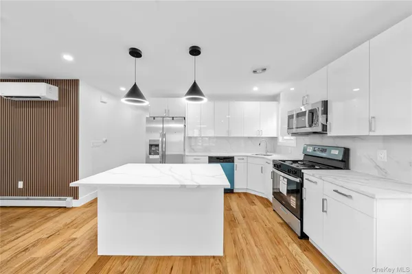 a kitchen with stainless steel appliances kitchen island wooden cabinets and a wooden floor