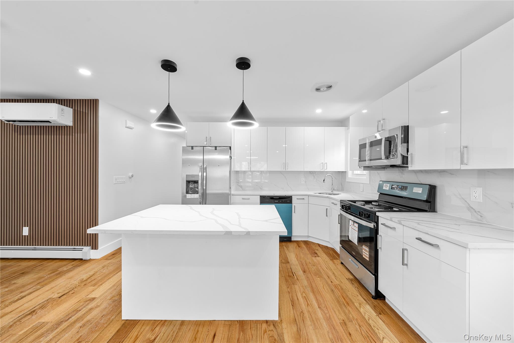 245-33 147th Road, Unit 1 Queens, NY 11422 - Photo 4 of 15 a kitchen with stainless steel appliances kitchen island wooden cabinets and a wooden floor