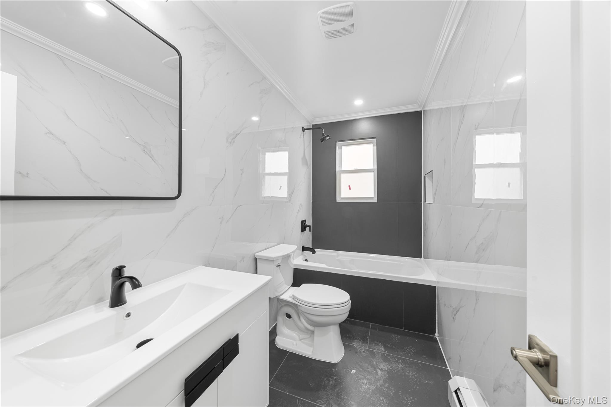 245-33 147th Road, Unit 1 Queens, NY 11422 - Photo 6 of 15 a bathroom with a sink a toilet and mirror