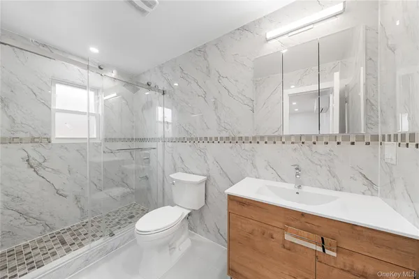 a bathroom with a sink a toilet and shower