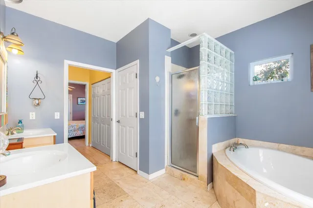 a bathroom with a tub a sink and a large mirror