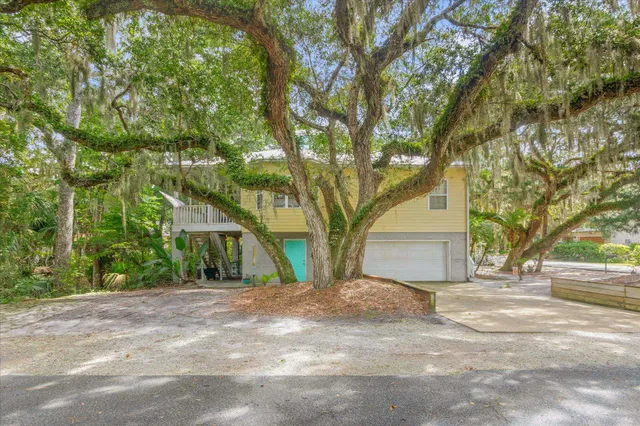 a front view of a house with a tree