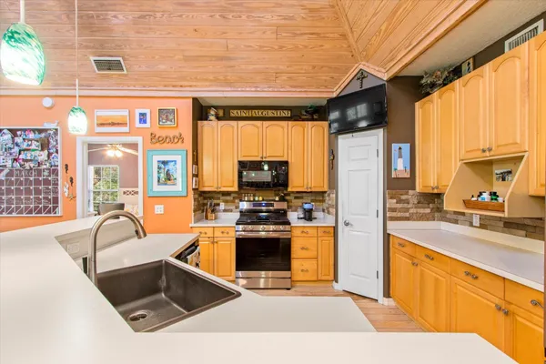 a kitchen with stainless steel appliances granite countertop a sink and a stove
