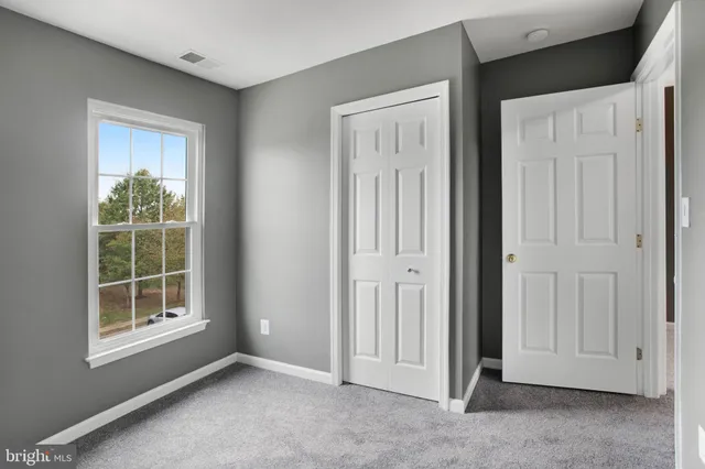 an empty room with windows and closet