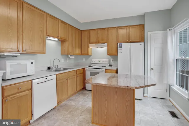 a kitchen with a refrigerator sink and cabinets