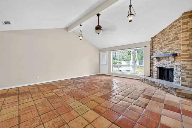 a view of an empty room with a fireplace and a window