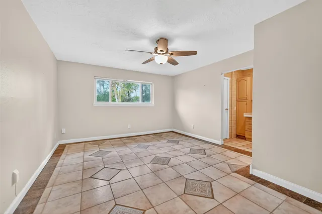 an empty room with windows and fan
