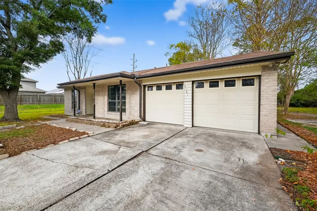 a view of a house with a yard and large tree