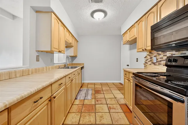 a kitchen with a sink stove and cabinets