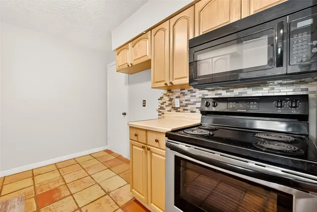 a stove top oven sitting inside of a kitchen