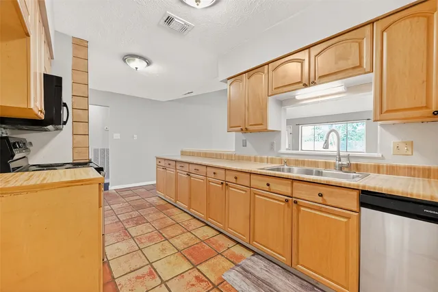 a kitchen with stainless steel appliances a sink and a refrigerator