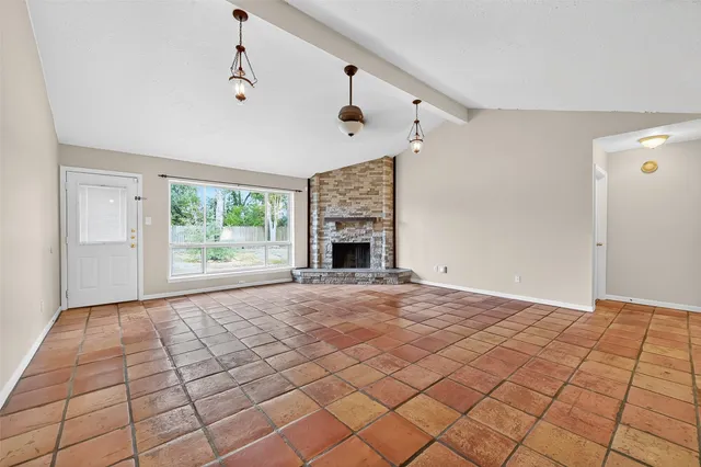 a view of an empty room with a fireplace and a window