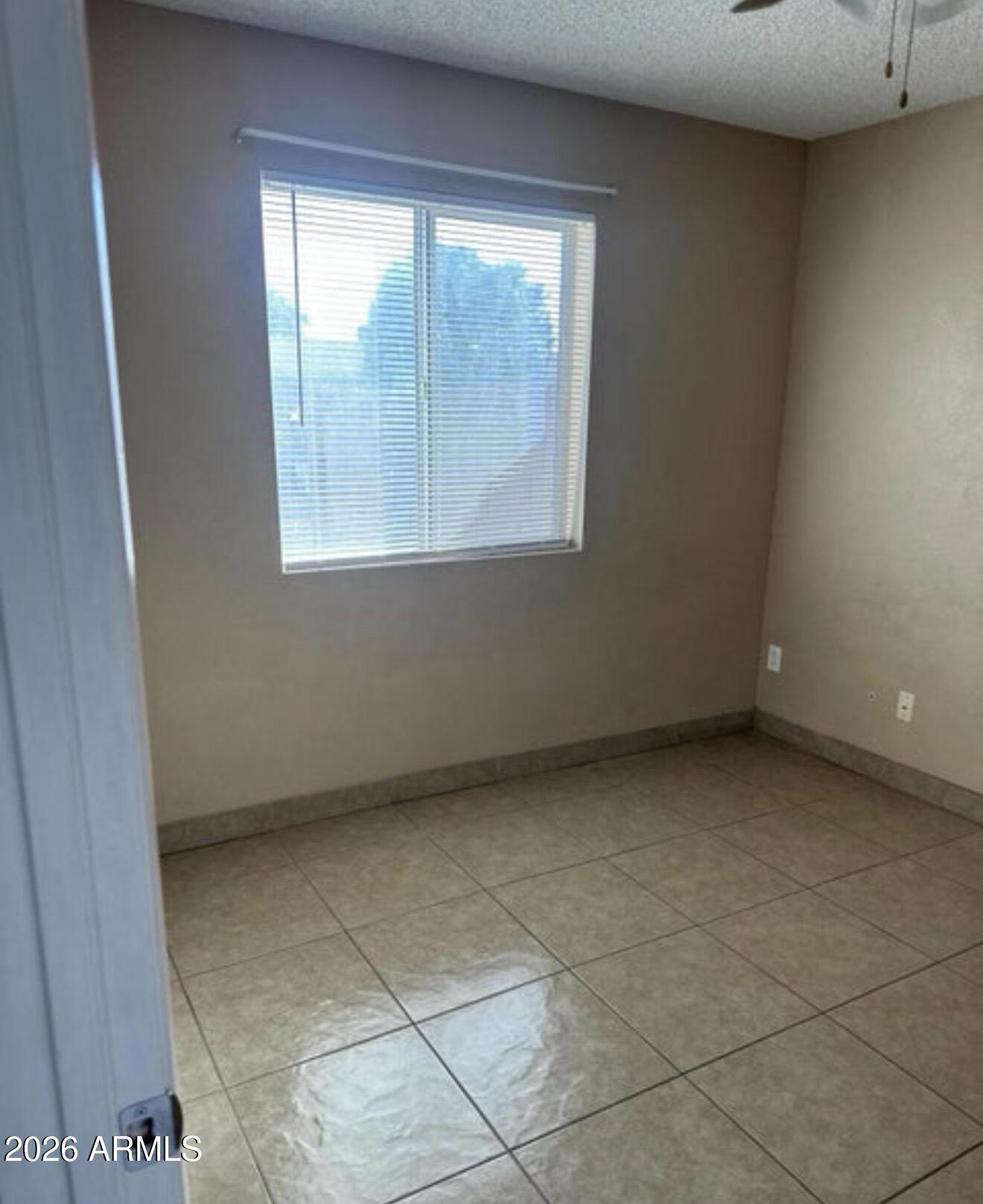 2916 North 87th Lane Phoenix, AZ 85037 - Photo 11 of 16 an empty room with a window