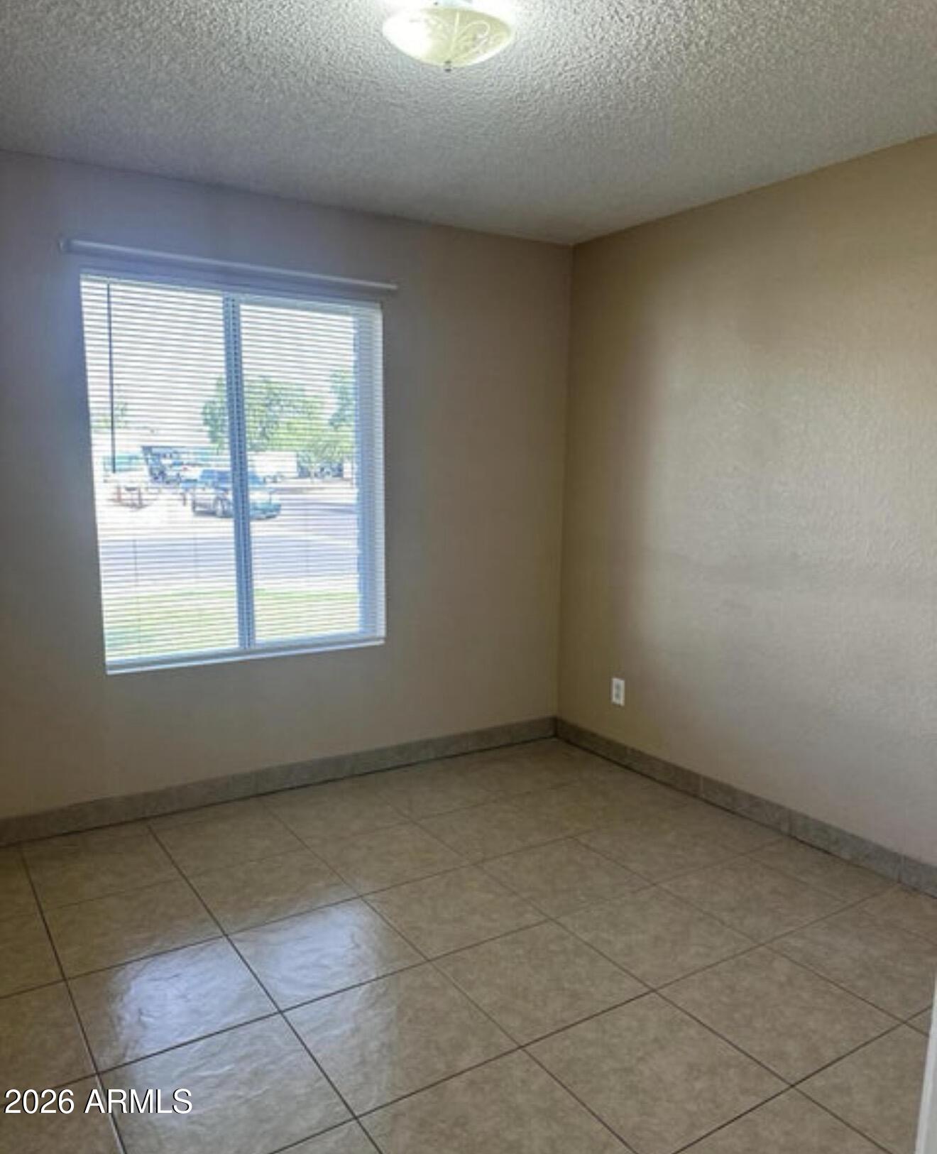2916 North 87th Lane Phoenix, AZ 85037 - Photo 12 of 16 an empty room with a window