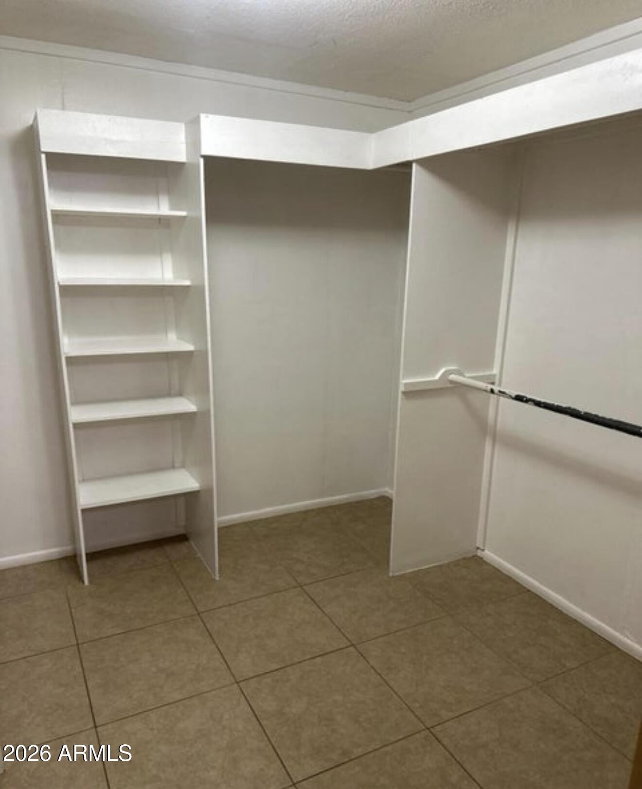 2916 North 87th Lane Phoenix, AZ 85037 - Photo 13 of 16 a view of an empty walk in closet
