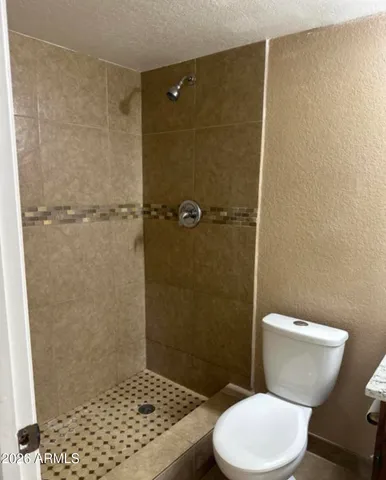 a bathroom with a granite countertop sink a toilet and mirror