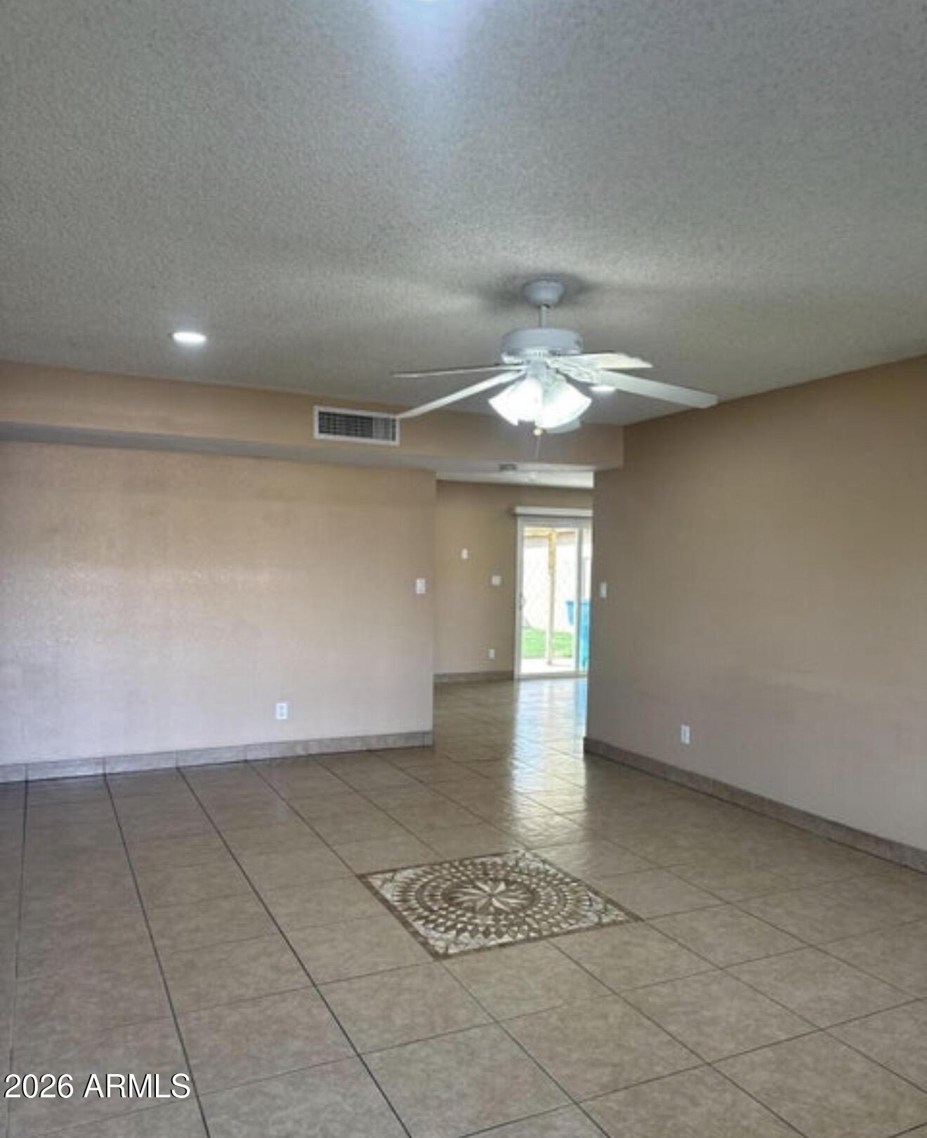 2916 North 87th Lane Phoenix, AZ 85037 - Photo 3 of 16 wooden floor in an empty room with a chandelier