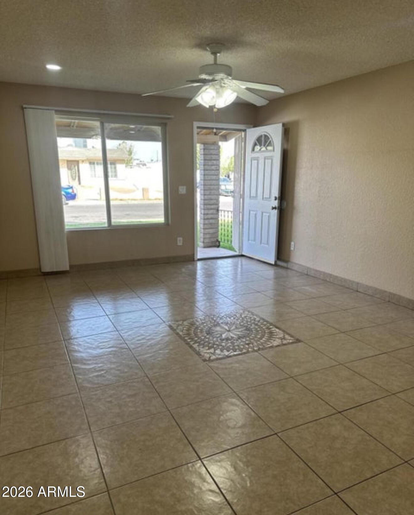 2916 North 87th Lane Phoenix, AZ 85037 - Photo 4 of 16 a view of an empty room with a window