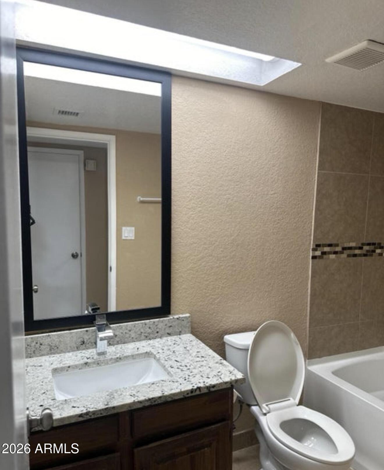 2916 North 87th Lane Phoenix, AZ 85037 - Photo 9 of 16 a bathroom with a granite countertop sink and a mirror