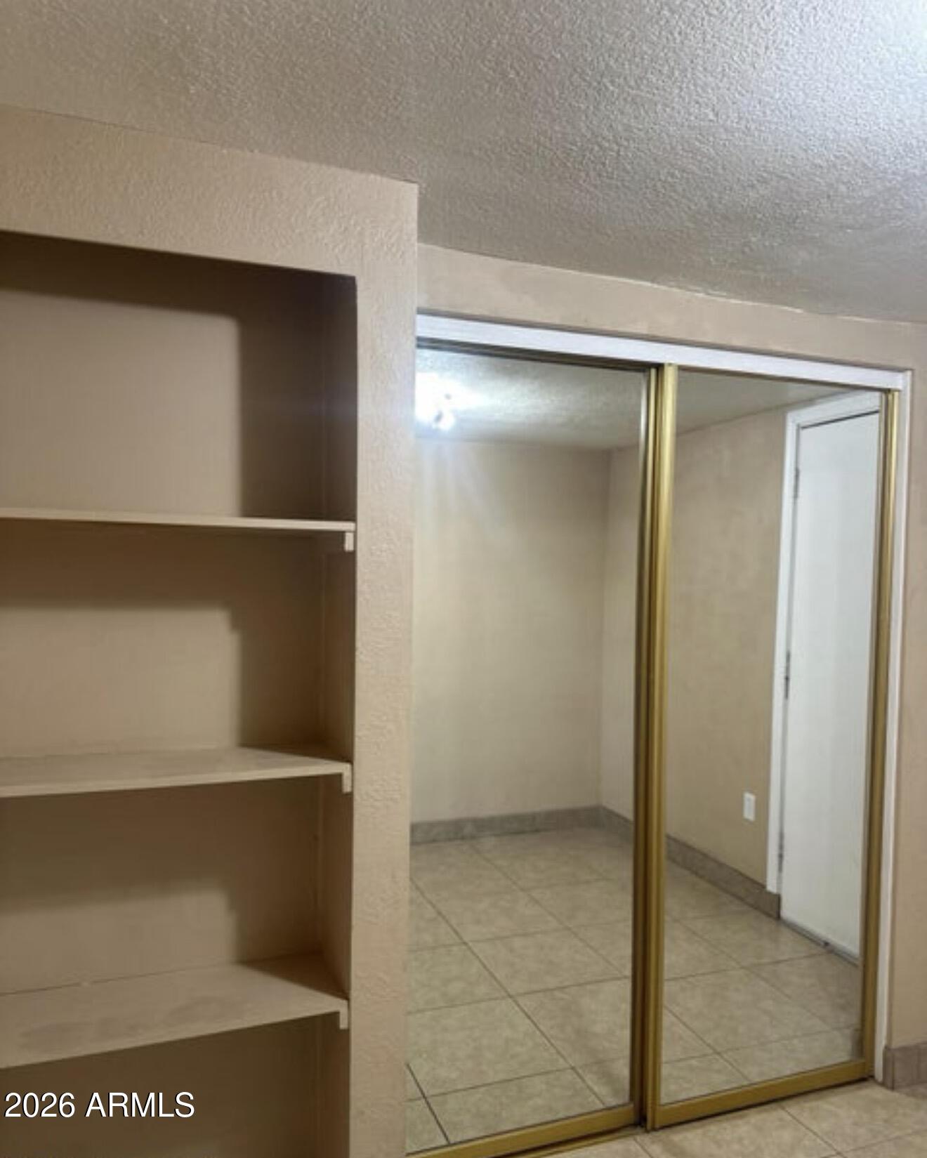 2916 North 87th Lane Phoenix, AZ 85037 - Photo 10 of 16 a view of walk in closet with empty racks