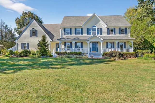 a front view of a house with garden and trees