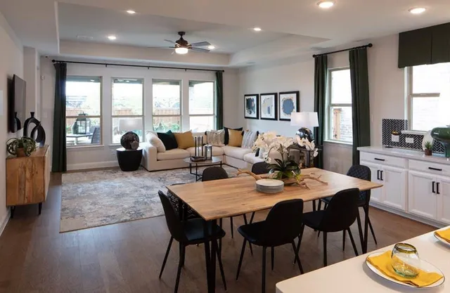 a living room with furniture floor to ceiling window and a flat screen tv