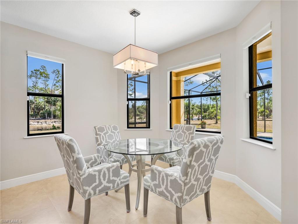 3160 27th Avenue Southwest Naples, FL 34117 - Photo 12 of 43 a view of a dining room with furniture wooden floor and chandelier