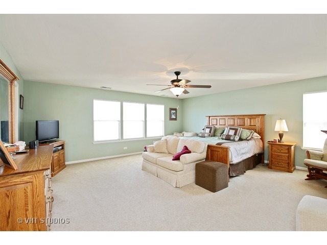 322 Monument Road Elgin, IL 60124 - Photo 11 of 15 a spacious bedroom with a bed and couch