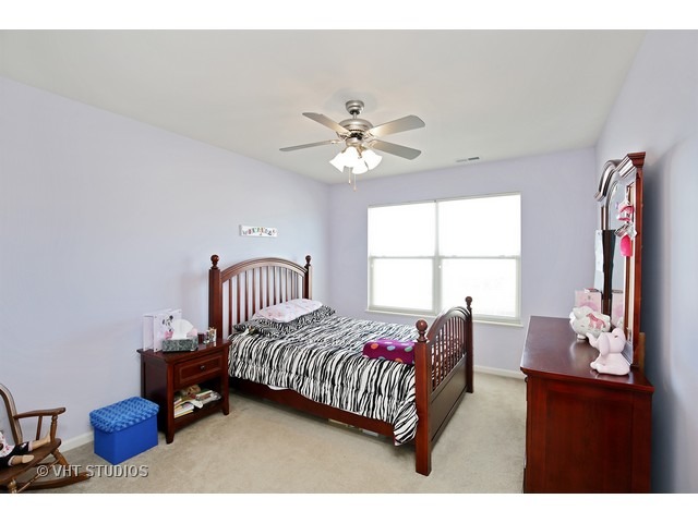 322 Monument Road Elgin, IL 60124 - Photo 13 of 15 a bedroom with a bed and a chandelier