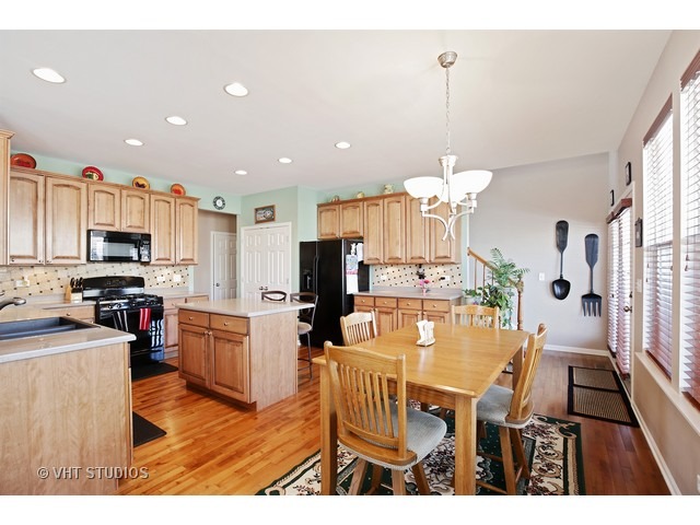 322 Monument Road Elgin, IL 60124 - Photo 6 of 15 a view of a dining room with furniture a kitchen and chandelier