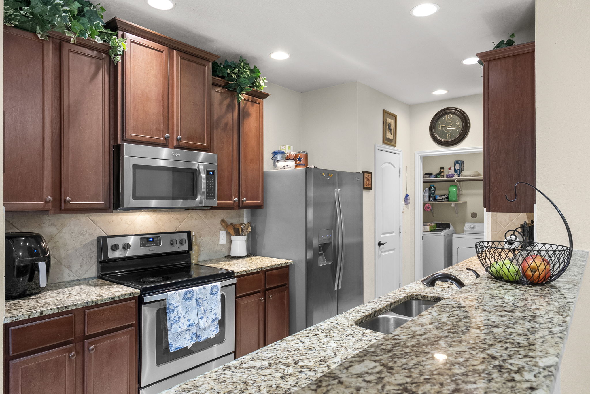 1617 Treeta Trail Kyle, TX 78640 - Photo 15 of 39 Kitchen featuring stainless steel appliances, light stone countertops, tasteful backsplash, separate washer and dryer, and recessed lighting
