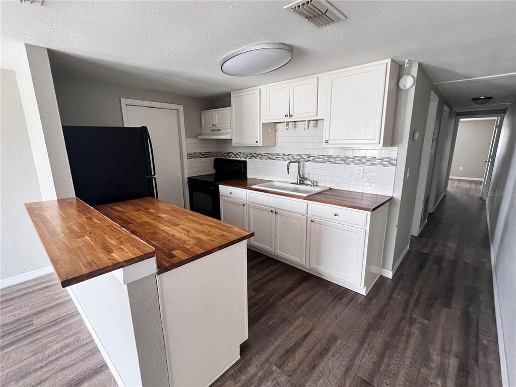 5650 Golden Nugget Drive Holiday, FL 34690 - Photo 2 of 9 a kitchen with stainless steel appliances granite countertop a sink stove and refrigerator
