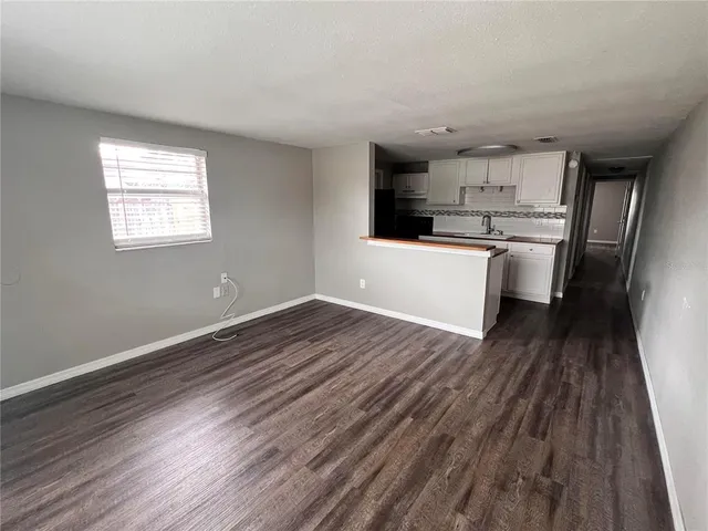a kitchen with a refrigerator and white cabinets