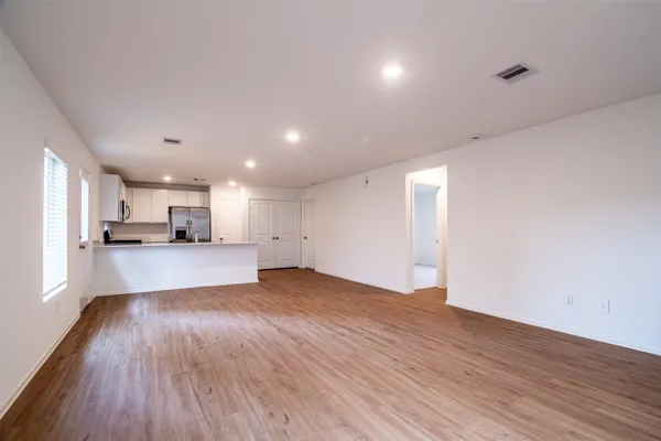 a view of kitchen with kitchen island wooden floors and stainless steel appliances