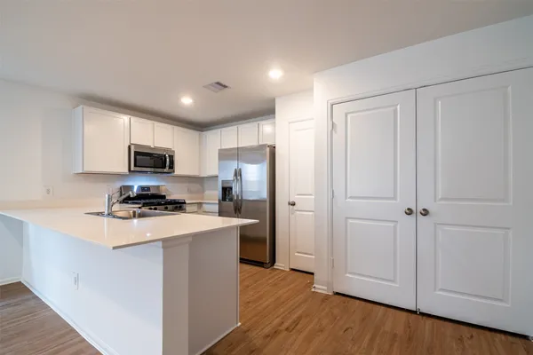 a kitchen with stainless steel appliances a refrigerator a stove a microwave and cabinets