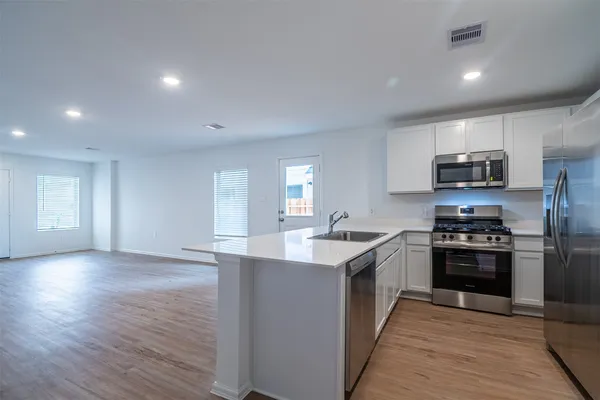 a kitchen with stainless steel appliances granite countertop a sink stove and refrigerator
