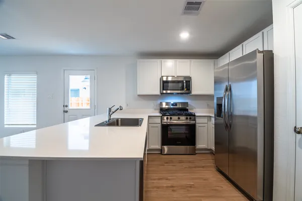 a kitchen with kitchen island a counter top space stainless steel appliances and cabinets