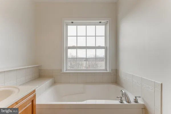 a white bath tub sitting in a bathroom next to a window