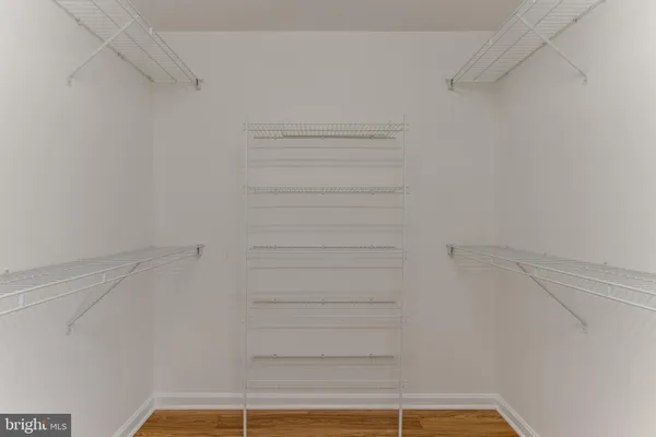 a view of walk in closet with empty racks