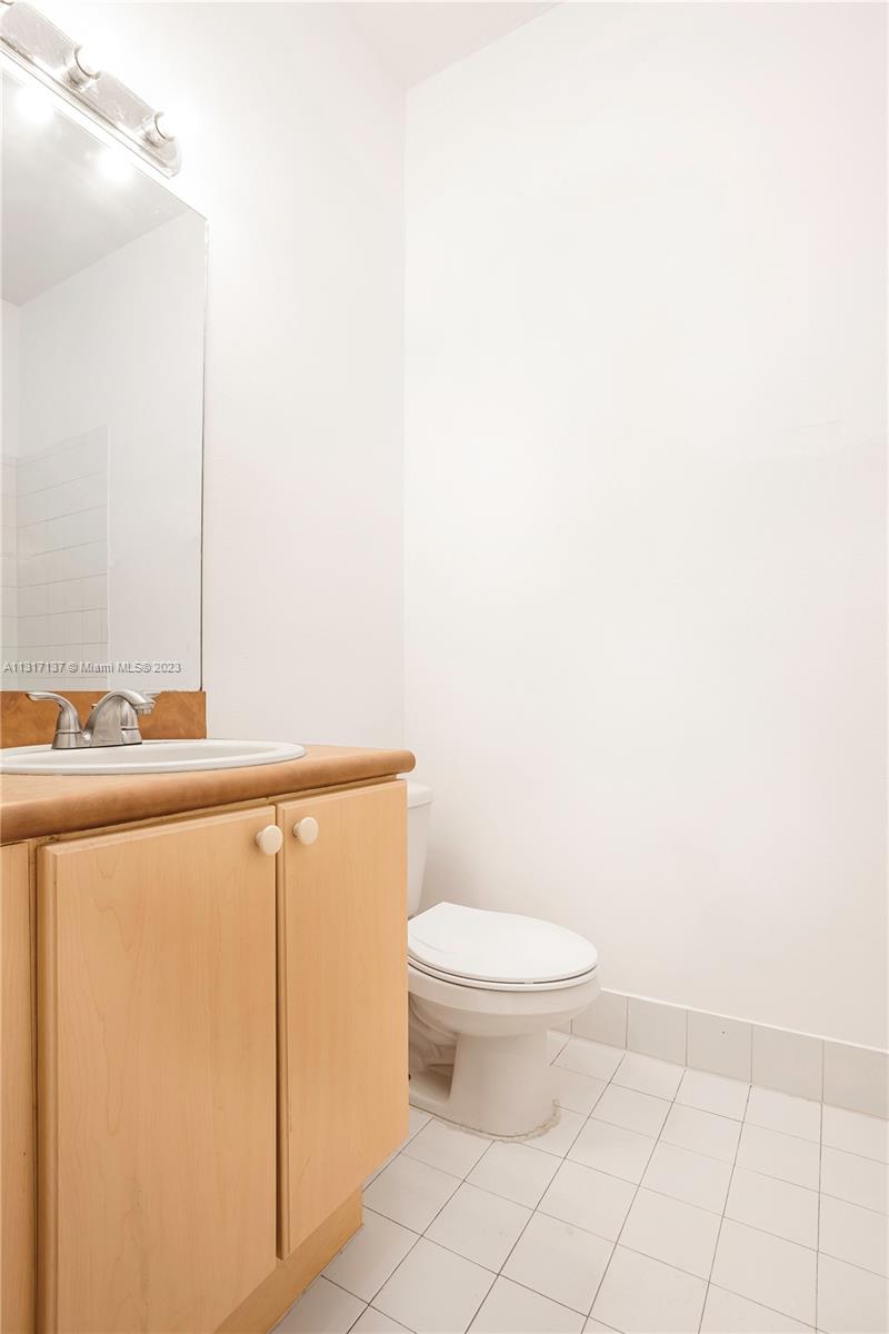 4971 Southwest 140th Terrace, Unit 6 Miramar, FL 33027 - Photo 14 of 24 a bathroom with a toilet a sink and mirror